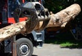 A close-up on a modern red tractor forest equipment, timber loader, knuckleboom log loader with a large tree trunk Royalty Free Stock Photo