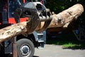 A close-up on a modern red tractor forest equipment, timber loader, knuckleboom log loader with a large tree trunk