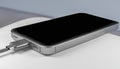 A modern smartphone is charged using a USB-C cable. Royalty Free Stock Photo