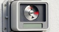Close-up of a modern smart device with a rapidly spinning metallic dial and red indicator lights, mounted on a white wall, Royalty Free Stock Photo