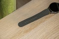Close-up of a modern smartwatch with a green silicone strap resting on a wooden surface, showcasing its design and funct Royalty Free Stock Photo