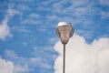 Modern stree lamp located on concrete floor beside road with blue sky background.