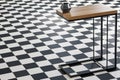 Close-up of a modern table with a small vase on a checkered floor