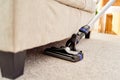 Close up of modern vacuum cleaner on beige carpet on floor in living room, copy space. Housework, household, spring-cleanig Royalty Free Stock Photo