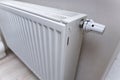 Close-up of a modern white radiator installed in an indoor setting. The image shows the heating control valve, emphasizi Royalty Free Stock Photo