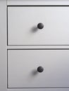 Close-up of a modern white wooden chest of drawers with black handles. Minimalism, modern interior Royalty Free Stock Photo