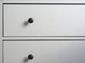 Close-up of a modern white wooden chest of drawers with black handles. Minimalism, modern interior Royalty Free Stock Photo