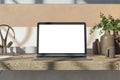 Close up of wooden designer desk top with empty white mock up place on laptop screen, coffee cup, supplies and other items