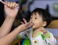 Close-up of mom hands clean the first teeth of her little baby son in the morning. Mother brushing teeth with a silicone fingertip Royalty Free Stock Photo