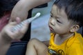 Close-up of mom hands clean the first teeth of her little baby son in the morning. Mother brushing teeth with a silicone fingertip Royalty Free Stock Photo