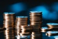 Close up: Money coins, stack, black background, with a blue filter