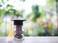 Close up money in the glass bottle with graduation hat. The concept of saving money for education, student loan, scholarship, Royalty Free Stock Photo