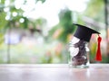 Close up money in the glass bottle with graduation hat. The concept of saving money for education, student loan, scholarship, Royalty Free Stock Photo
