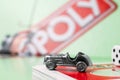 Close up of monopoly car, monopoly board and dices on the monopoly chance cards Royalty Free Stock Photo
