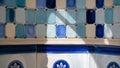 Close up of a mosaic tiled wall with blue and white geometric patterns and sunlight casting shadows Royalty Free Stock Photo