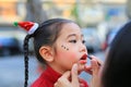 Close up mother applying lipstick over daughter mouth Royalty Free Stock Photo