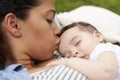 Close Up Of Mother With Baby Relaxing On Rug In Garden