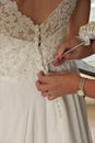 Close up of Hands Doing Final Buttoning of Bride& x27;s Wedding Dress Royalty Free Stock Photo