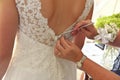 Close up of Hands Doing Final Buttoning of Bride& x27;s Wedding Dress Royalty Free Stock Photo