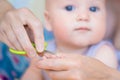 Close-up mother cutting nail of baby with safety scissors. Mom trimming child fingernails. Children healthcare and hygiene concept