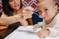 Close up of mother feeding her baby, sitting in a high chair Royalty Free Stock Photo