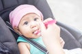 Close up mother hand, a spoon of baby food feeding her little cute baby girl for dinner. Baby look at her mother Royalty Free Stock Photo