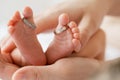 Close up of mother hands holding tiny baby feet with care, Mother Baby concept. Royalty Free Stock Photo