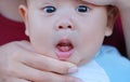 Close-up mother hands open baby mouth to examine first teeth. Infant primary tooth