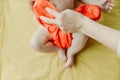 Close up of mother hands put on a baby orange diaper to her newborn Royalty Free Stock Photo