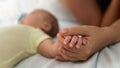 Close up mother holding hands newborn boy in a room with a lot of sunlight. Baby Royalty Free Stock Photo