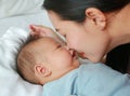 Close up mother kissing baby boy lying on the bed Royalty Free Stock Photo