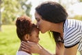 Close Up Of Mother Kissing Daughter In Park