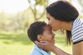 Close Up Of Mother Kissing Son In Park