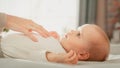 Close Up of a Mother Playing with a Cute Newborn Baby that is Lying on the Back in Child Crib in Royalty Free Stock Photo