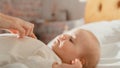 Close Up of a Mother Playing with a Cute Newborn Baby that is Lying on the Back in Child Crib in Royalty Free Stock Photo