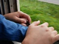 Close up of mother`s and little baby`s hands together holding on a frame of an opened window on a traveling train