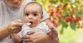 Close up of mother with spoon feeding little baby