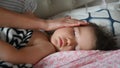 Close up of mother stroking head of sleeping baby son. Caring for child concept. Royalty Free Stock Photo