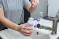 Close up of mothers hands cleaning a baby milk bottle with a brush, home kitchen sink Royalty Free Stock Photo