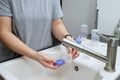 Close up of mothers hands cleaning a baby milk bottle with a brush, home kitchen sink Royalty Free Stock Photo