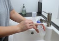 Close up of mothers hands cleaning a baby milk bottle with a brush, home kitchen sink Royalty Free Stock Photo