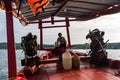 A close-up of a motor engine on a Cambodian longtail boat with captain