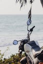 Close-up of a motorcycle against the sea and palm tree