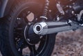 Close-up motorcycle exhaust pipe with classic wheel