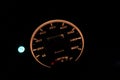 Close-up of motorcycle speedometer at night.