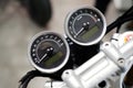 Close-up of a motorcycle speedometer with a reflection from the sensor and chrome upper handle after washing and wax. View from
