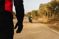 Close-up of a motorcyclist walking towards his motor y leer on the road to go on the adventure trip or a competition race Royalty Free Stock Photo