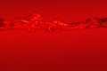Close-up of the movement of water on a red background. Royalty Free Stock Photo