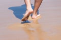 Close up on moving feet of a man walking on the beach