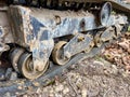 Close-up of muddy excavator track with metal rollers on dirt ground Royalty Free Stock Photo